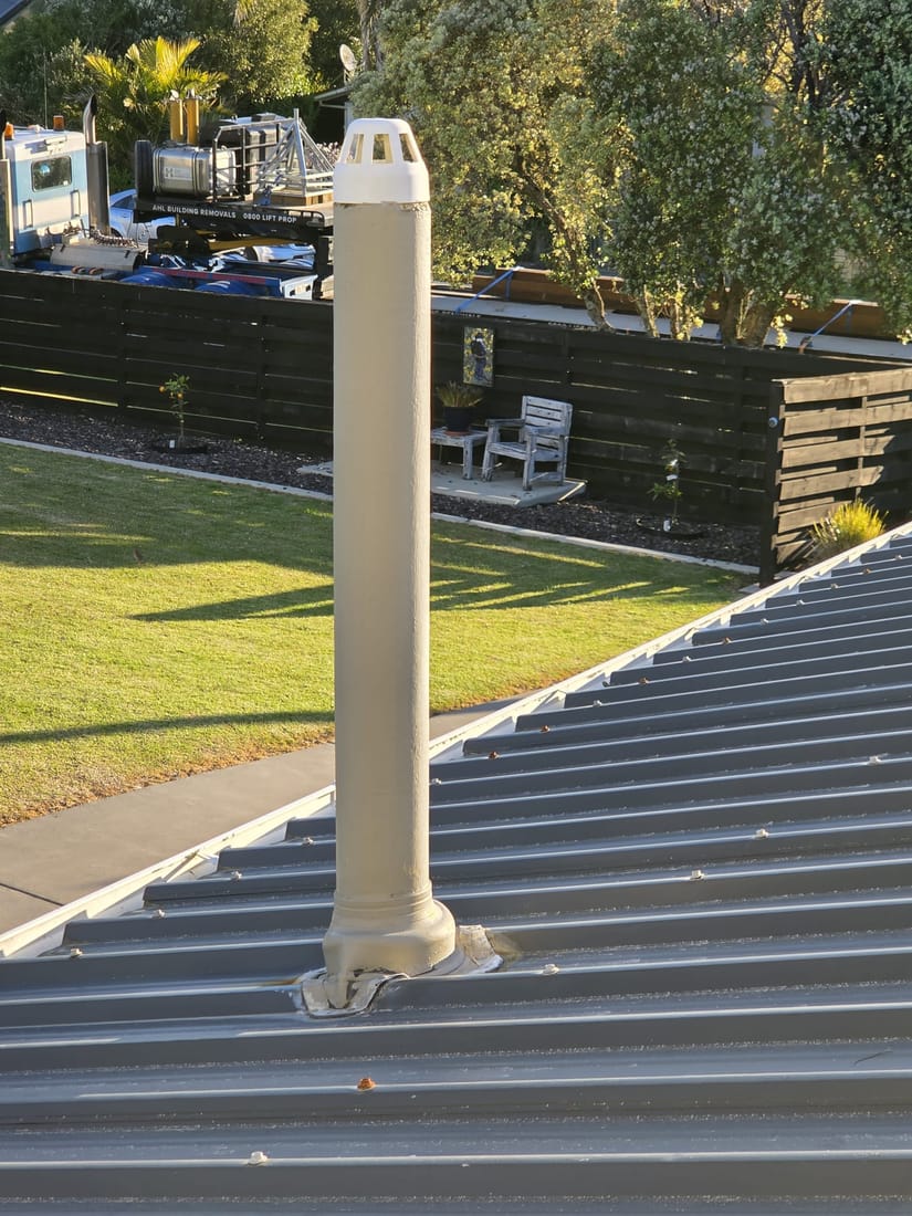 Original asbestos-cement toilet vent pipe protruding through a re-roofed roof